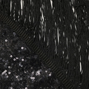Dettaglio macro di paillettes nere e lunghe nappe su un tessuto per abiti da sera