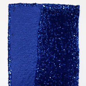 Detail of royal blue sequined fabric showing metallic shimmer and pleated texture