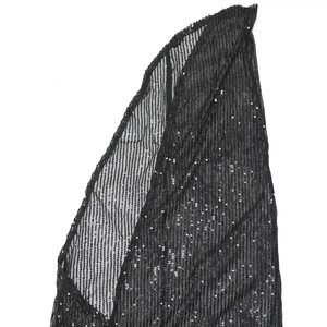 Detailed macro shot of vertical black sequins on a sheer mesh evening dress fabric