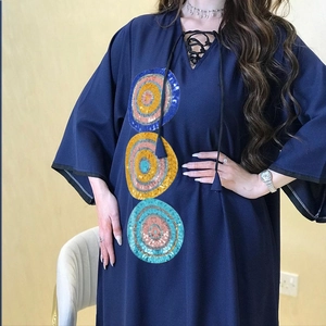 Detail showing colorful sequin circular embroidery on navy blue V-neck dress fabric