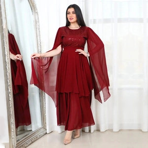 Detail of burgundy evening gown featuring sequined bodice and flowing chiffon cape sleeves