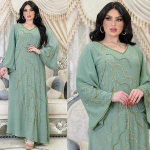 Détail de la robe longue vert sauge avec broderies de sequins dorés et cristaux