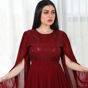 Detail of burgundy sequin evening dress featuring sheer split cape sleeves and a round neck