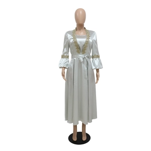 Detail of satin evening gown with golden lace embroidery on lantern sleeves and cuffs