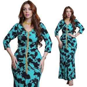 Detail of teal and black floral print kaftan dress with golden sequin V-neckline