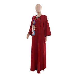 Close-up of V-neck tie detail and colorful sequin embroidery on dark red maxi dress