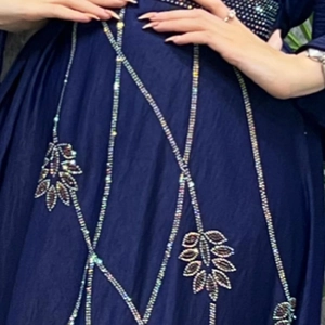 Detailed view of rhinestone leaf patterns on a navy blue abaya with sequin accents