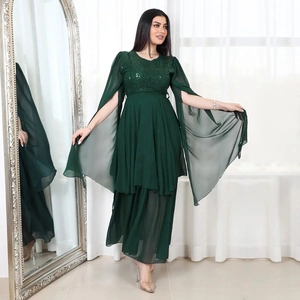 Detail of dark green sequin evening dress featuring split cape sleeves and layered skirt