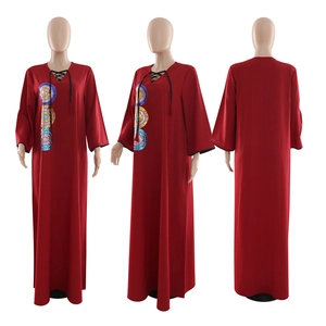 Detail of red V-neck abaya dress featuring sequin embroidery and decorative neck ties