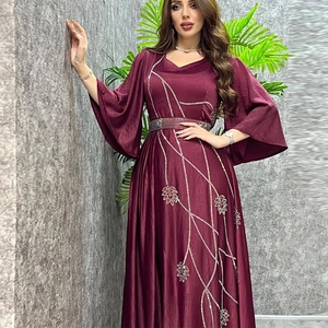 Detail of burgundy satin dress showing sparkling leaf rhinestones and beaded waist belt