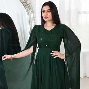 Detail of dark green sequin bodice and flowing chiffon cape sleeves on evening gown