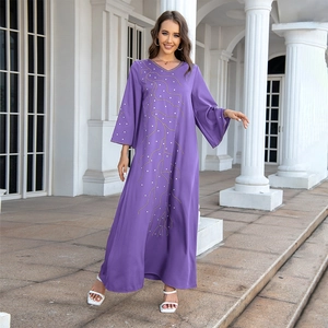 Détail d'une robe longue violette avec col en V, broderies dorées et manches évasées