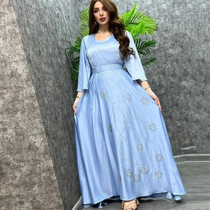 Detail of silver leaf sequins on long-sleeved light blue kaftan dress with flared sleeves
