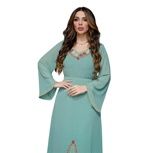 Détail de la robe en mousseline vert menthe avec perles rouges et blanches et strass raffinés