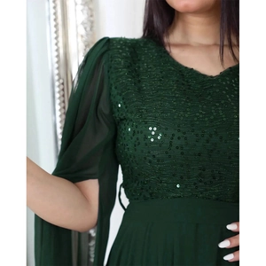 Detailed view of dark green sequins on mesh fabric and sheer tulle puff sleeves