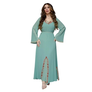 Détail de la robe maxi en mousseline vert menthe avec perles orange et manches évasées