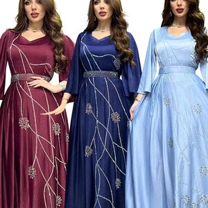 Detailed view of elegant leaf patterns and rhinestone waist belts on floor-length evening gowns