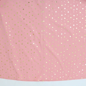 Dettaglio del tessuto kaftan rosa con eleganti pois dorati e finitura laminata