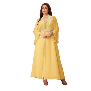 Detail of elegant mustard yellow kaftan with silver sequin embroidery and flared sleeves