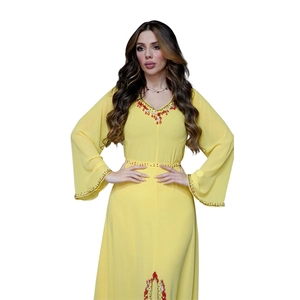 Détails d'un caftan en mousseline jaune avec broderies de perles rouges et dorées