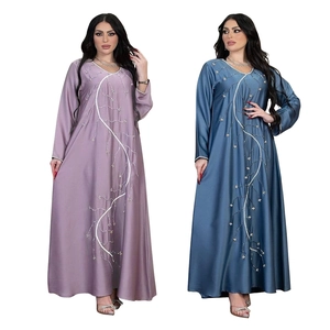 Close-up of elegant abaya dresses with white vine beadwork and silk-like glossy fabric