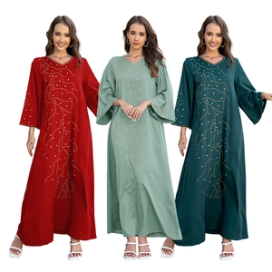 Détail de robe abaya ample avec motifs dorés et perles en trois couleurs variées