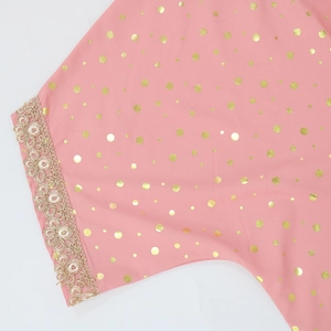 Dettaglio del tessuto kaftan rosa con pois in lamina d'oro e bordo in pizzo dorato