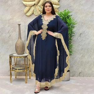 Détail d'une robe caftan bleu marine avec broderie dorée et longues franges aux manches