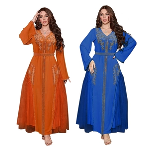 Detailed view of orange and blue kaftans with golden embroidery and rhinestone accents