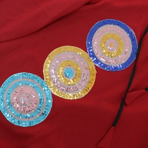 Close-up of sequin embroidery details on relaxed V-neck tunic dress with colorful patterns