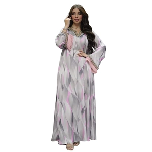 Detailed view of pink tassel cuffs and wave print on an elegant long-sleeve dress