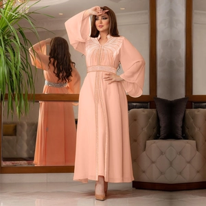 Detail of peach kaftan gown with intricate sequin embroidery and bell sleeves displayed in mirror