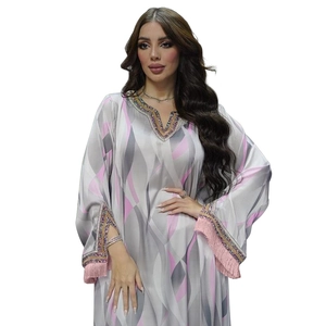 Detail of V-neckline with colorful sequin embroidery and pink tassels on satin kaftan