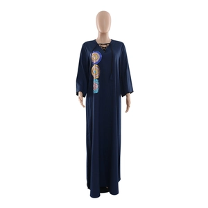 Detail of navy blue kaftan dress featuring colorful sequin embroidery and a V-neck tie