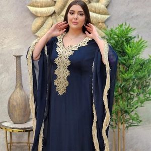Vue détaillée d'un caftan bleu marine avec broderie dorée et détails de longs glands