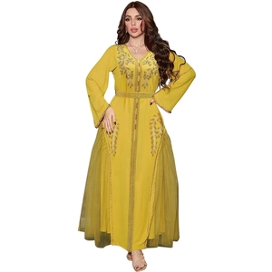 Detail of yellow kaftan dress featuring gold embroidery, rhinestones and mesh pleats