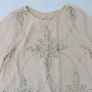 Detailansicht aus rosa Chiffon mit goldenen Strasssteinen in Schneeflocken-Mustern