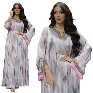 Detail of V-neckline with gold beads and pink tassels on floral print kaftan dress