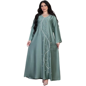 Detail of beaded embroidery and sequin floral patterns on a satin sage green kaftan dress