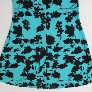 Detail of the turquoise fishtail hem with black floral prints and double-stitched seams