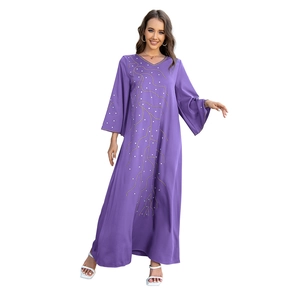 Détail du motif branche en strass étincelants sur une robe longue violette ample