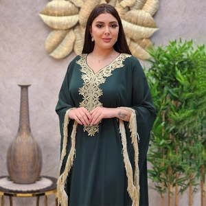 Détails de broderies florales dorées et poignets à franges sur une robe caftan vert