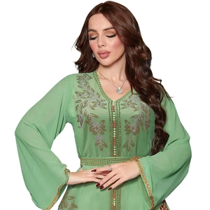 Macro shot of mint green kaftan dress with gold floral embroidery and beaded detailing
