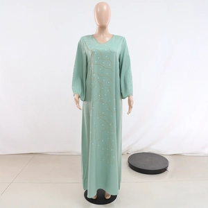 Détails de la robe abaya vert menthe avec broderie de perles dorées et strass brillants