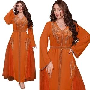 Detail of orange kaftan dress featuring gold leaf embroidery and rhinestone accents