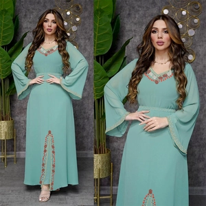 Détail d'une robe en mousseline vert menthe avec sequins ethniques et manches évasées