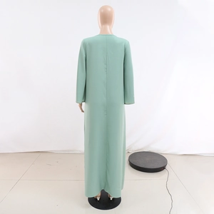 Détail d'une robe abaya longue vert clair avec une élégante bordure dorée aux poignets