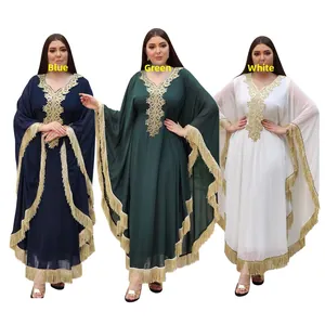 Détails de broderies dorées et pompons sur des robes caftans de style ethnique