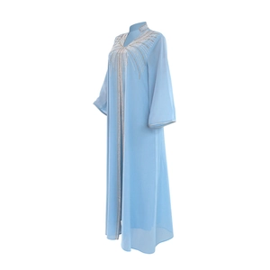 Close-up of sparkling rhinestones on light blue chiffon kaftan dress with long sleeves