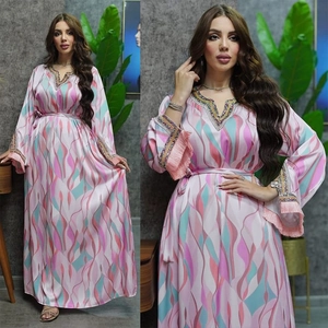 Close-up of pink satin kaftan with colorful sequin embroidery and tassel cuffs